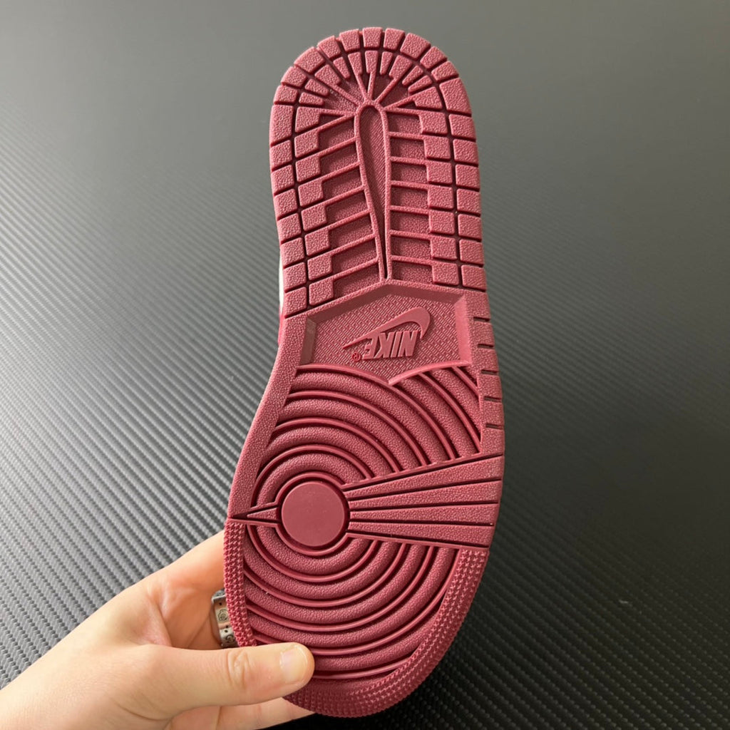 Shoe outsole with burgundy tread pattern and central herringbone-style grip