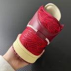 Back view of mid-top sneakers with red woven heel panel and beige outsole