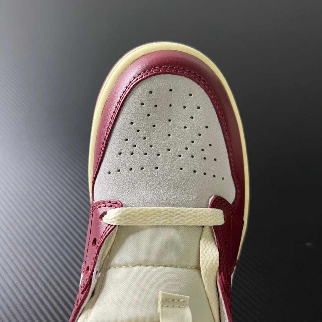 Front top of mid-top sneakers with perforated white toe and burgundy laces overlay