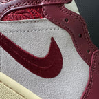 Close-up of white leather side panel with burgundy Nike swoosh and burgundy stitching