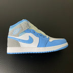 Mid-top sneakers with white panels and light blue overlays, Air Jordan wings logo on heel.