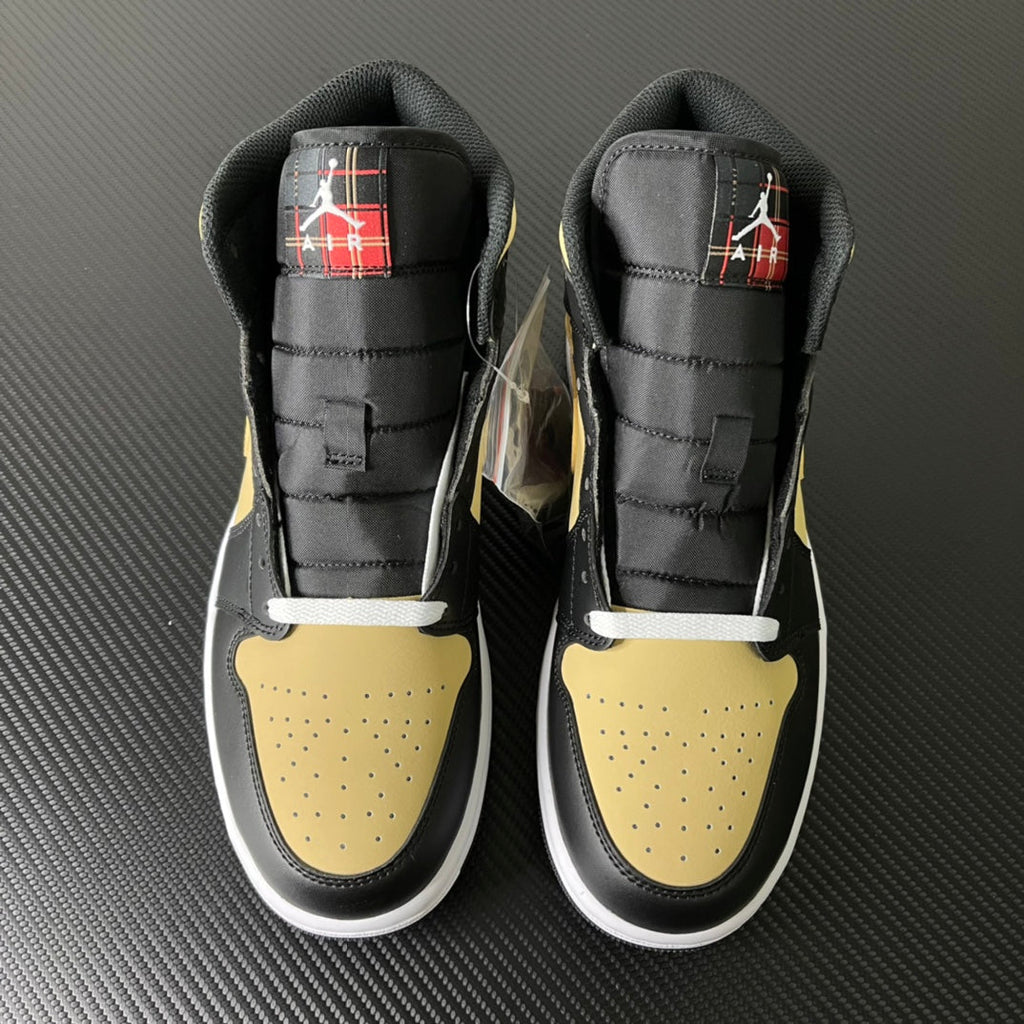 Pair of mid-top sneakers, black uppers with yellow toe panels and red tartan accents