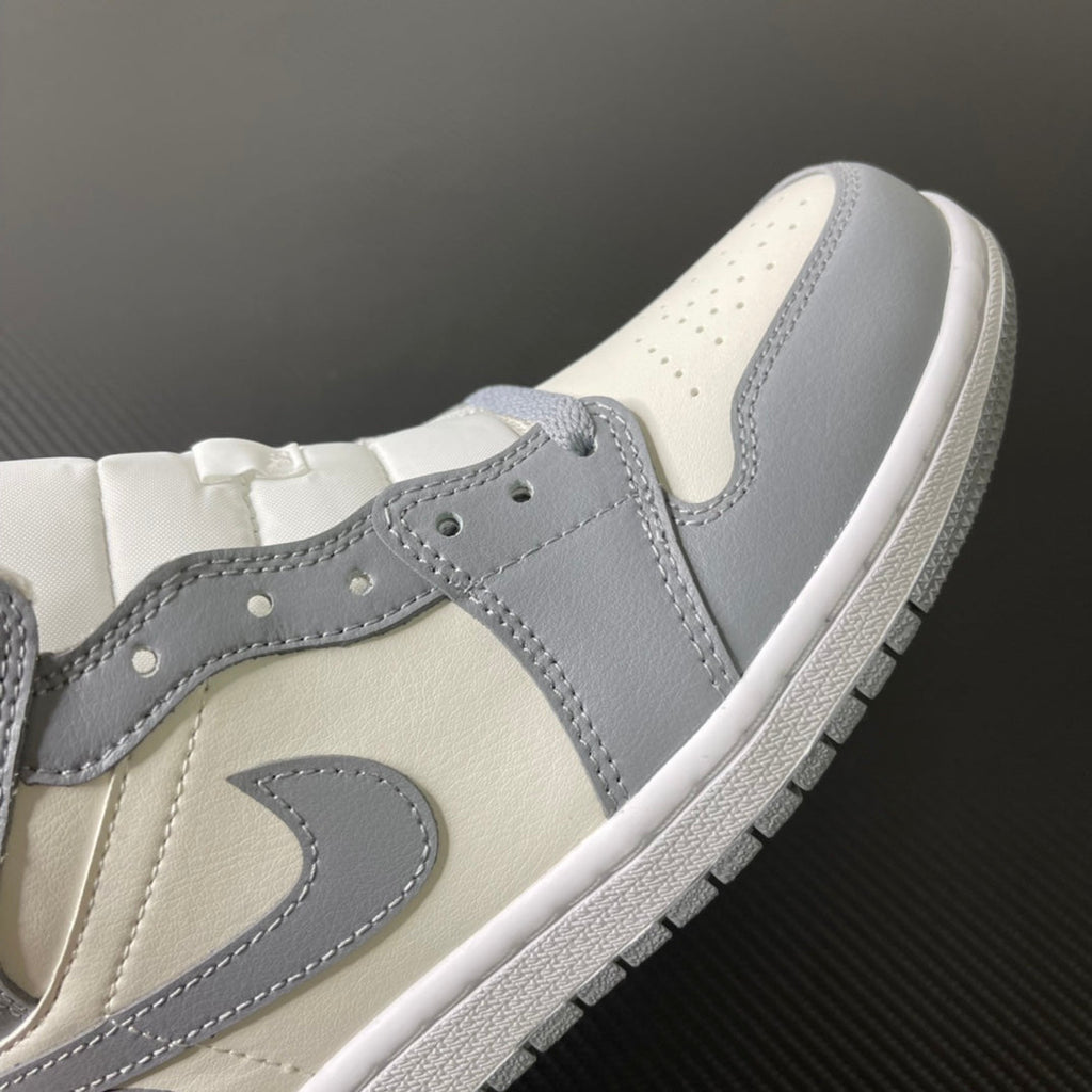 Air Jordan 1 Mid sneaker upper close-up with grey overlays and sail toe