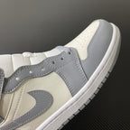 Air Jordan 1 Mid sneaker upper close-up with grey overlays and sail toe