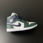 Mid-top sneakers with white leather panels, green overlays, and navy swoosh detail