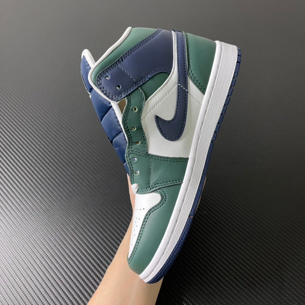 Mid-top sneakers angled side view with green laces eyelets and navy/white trim