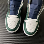 Pair of mid-top sneakers with white perforated toe and green leather side panels