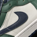 Close-up of mid-top sneaker swoosh on white leather with green trim and navy stitching