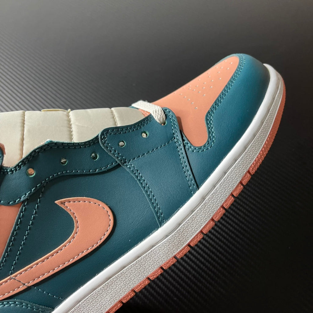 Air Jordan 1 Mid sneaker detail view, teal blue leather upper with peach Swoosh and laces.