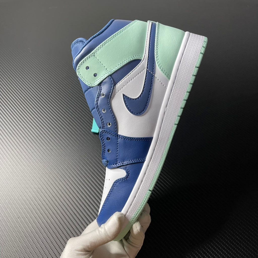 Mid-top sneakers held up, blue and white uppers with mint outsole edge