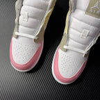 Air Jordan 1 Mid pair shown from front with white uppers, pink toe panels, and perforations