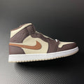 Mid-top Air Jordan 1 sneaker with cream, dark brown, tan swoosh and white sole