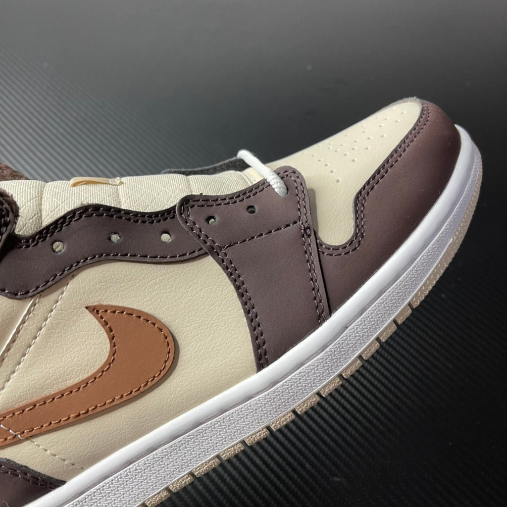 Mid-top Air Jordan 1 panel close-up, cream leather with dark brown overlays and tan swoosh