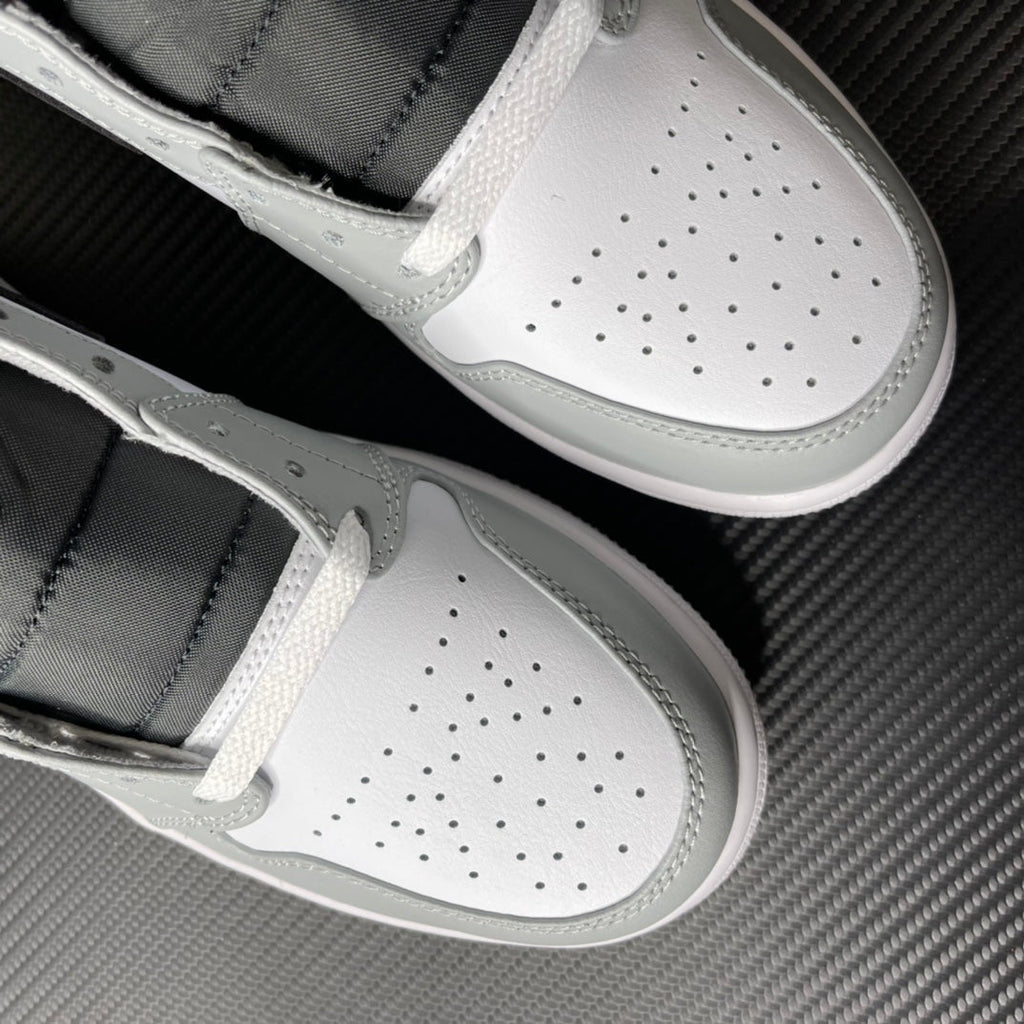 White and light gray mid-top sneakers with perforated toe box