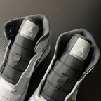 Two light gray and white mid-top sneakers with Air logo heel tabs