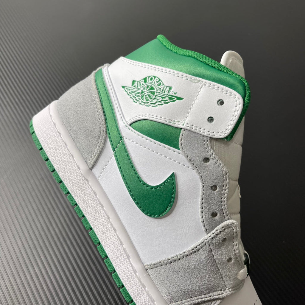 Mid-top sneaker side view with white leather overlays and green inner lining