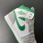 Mid-top sneaker side view with white leather overlays and green inner lining