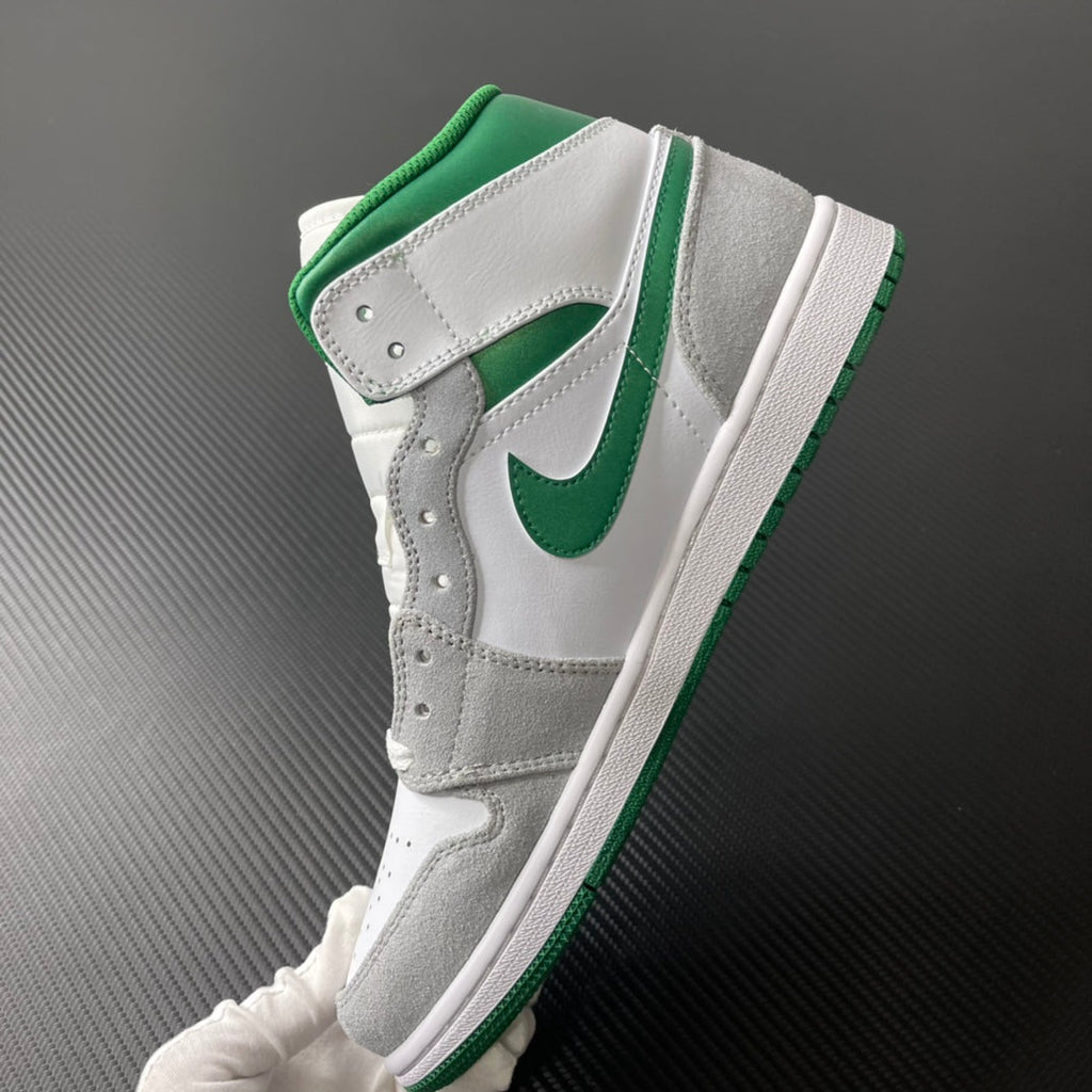 Mid-top sneaker side view with green Swoosh, white leather, and gray overlays