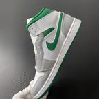 Mid-top sneaker side view with green Swoosh, white leather, and gray overlays
