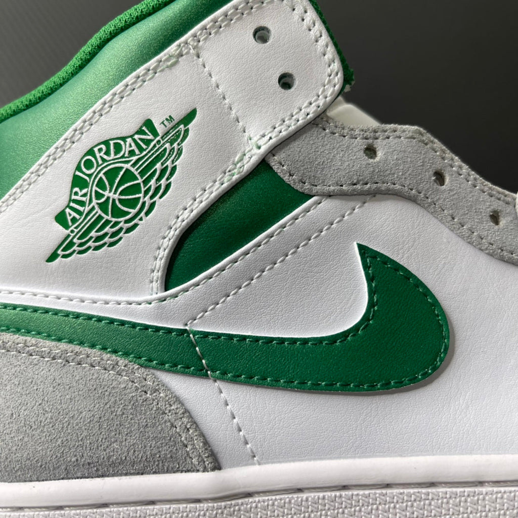 Air Jordan logo patch and green Swoosh on white leather mid-top sneaker