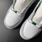 Pair of sneakers with perforated white toe, green detail, and gray suede trim