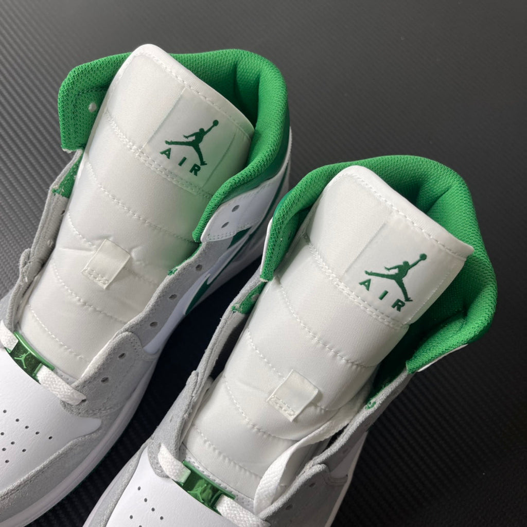 Pair of sneakers showing white tongue labels with green Air Jordan logo