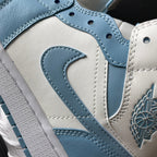 Jordan 1 Mid sneaker detail: light blue swoosh, stitching, and wing logo on white leather