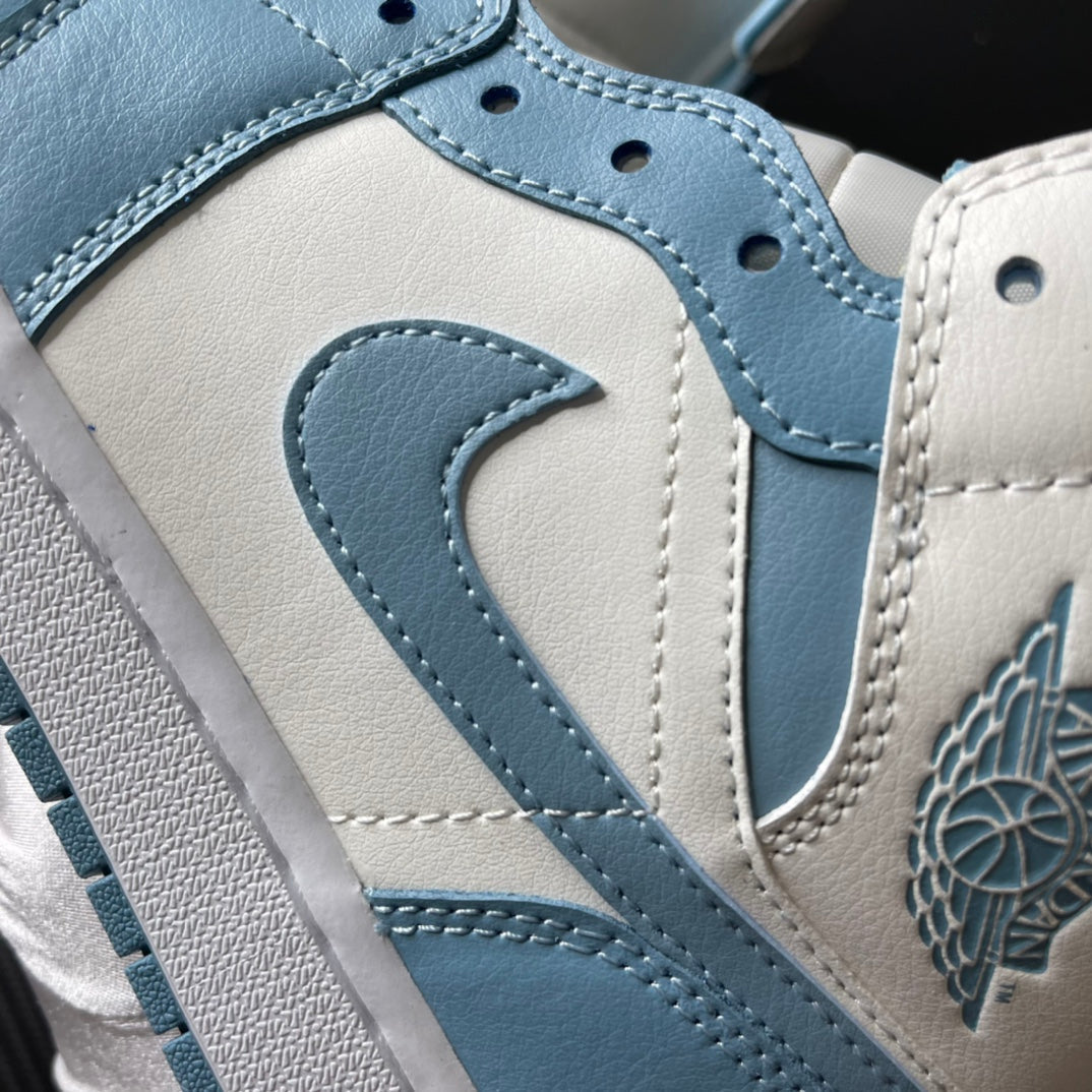 Jordan 1 Mid sneaker detail: light blue swoosh, stitching, and wing logo on white leather