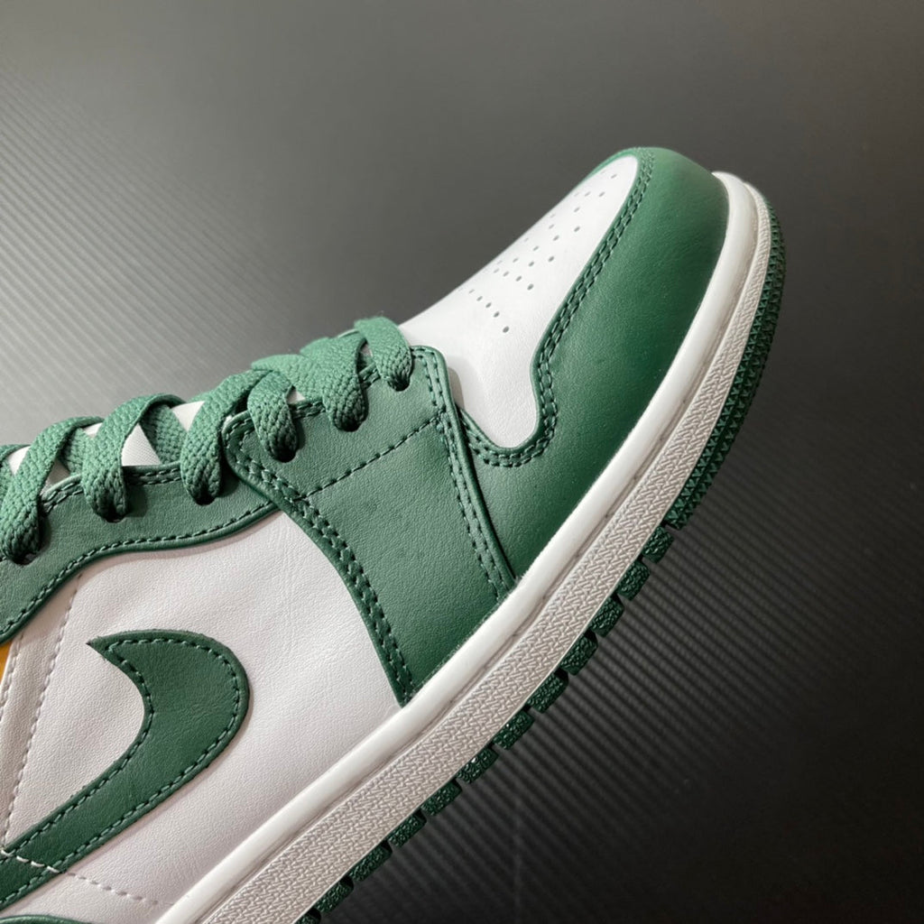 Mid-top sneakers toe and side view; green leather with white accents and lace-up.