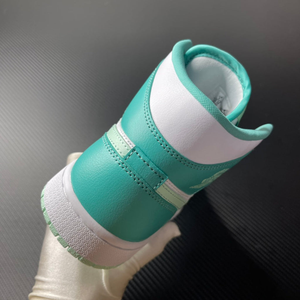 Back view of white and teal mid-top sneakers with padded collar and stitched seams