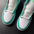 Pair of white and teal mid-top sneakers with white perforated toe and teal laces