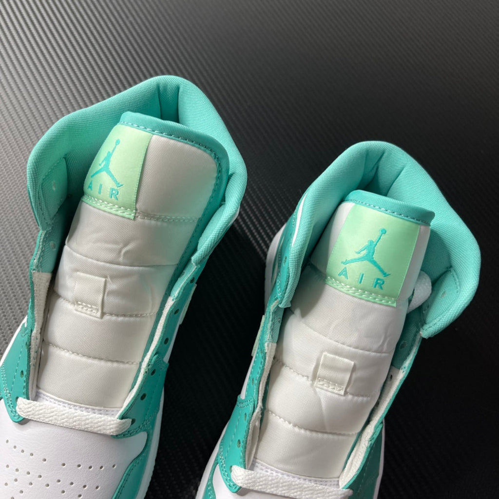 Inside view of white and teal mid-top sneakers with padded tongues and Air logo