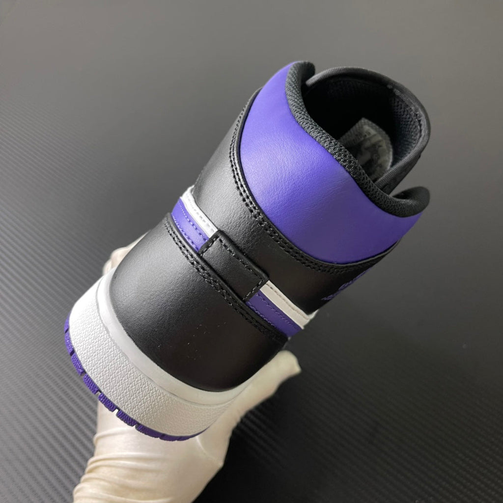 Air Jordan 1 Mid sneaker heel with black leather, purple collar, and white midsole
