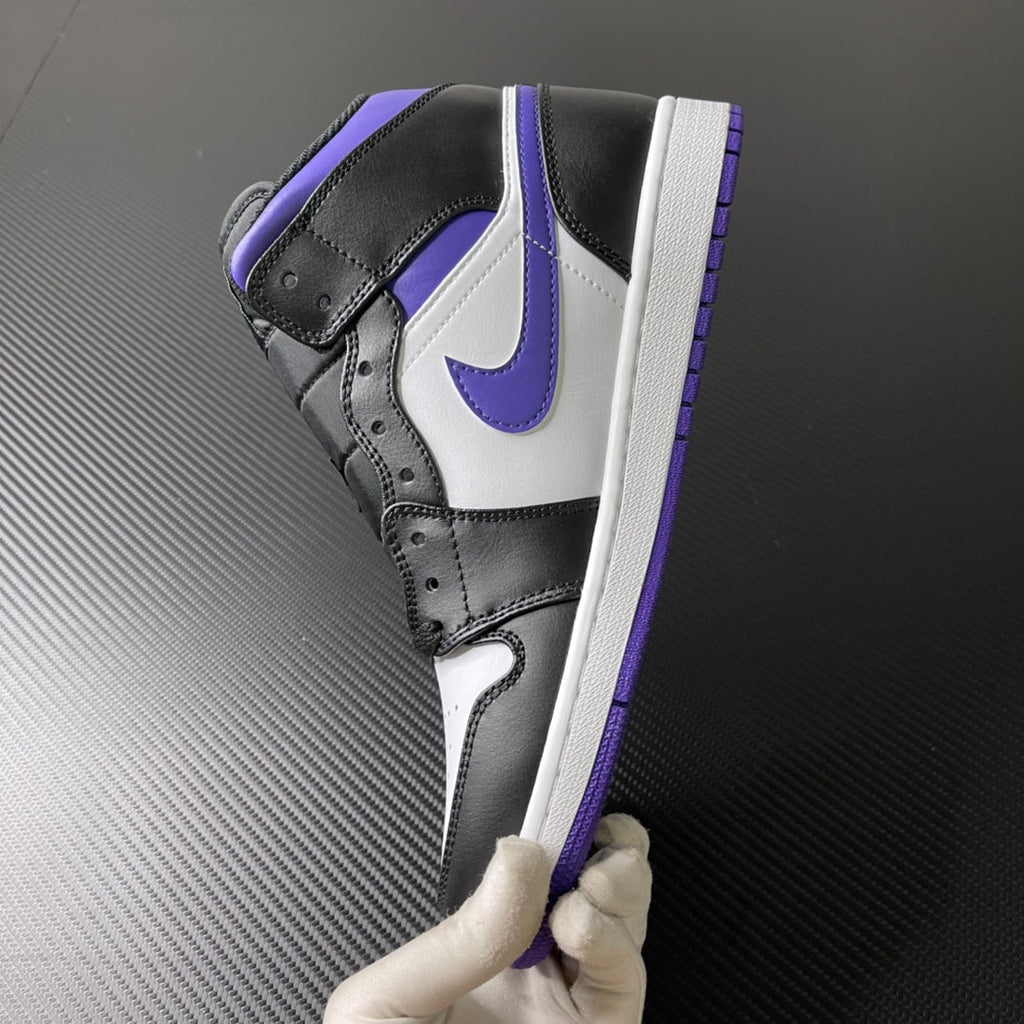 Air Jordan 1 Mid angled view with black upper, white side panel, and purple trim