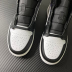 Pair of Air Jordan 1 Mid shoes from front, black sidewalls and white perforated toe