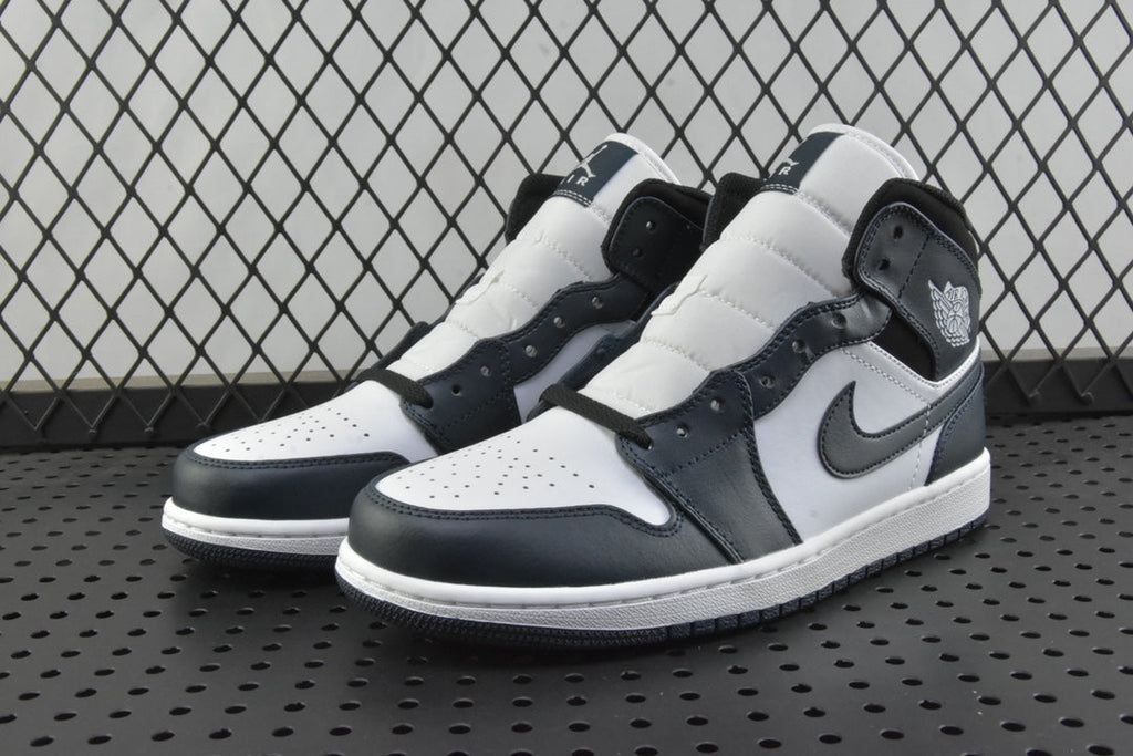 Pair of mid-top sneakers in white, dark teal, and black with lace-up front