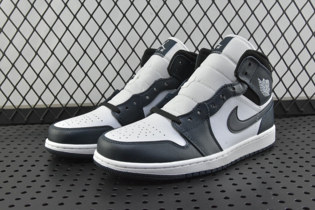Pair of mid-top sneakers in white, dark teal, and black with lace-up front