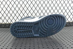 Outsole view of mid-top sneakers with dark teal traction tread and white upper