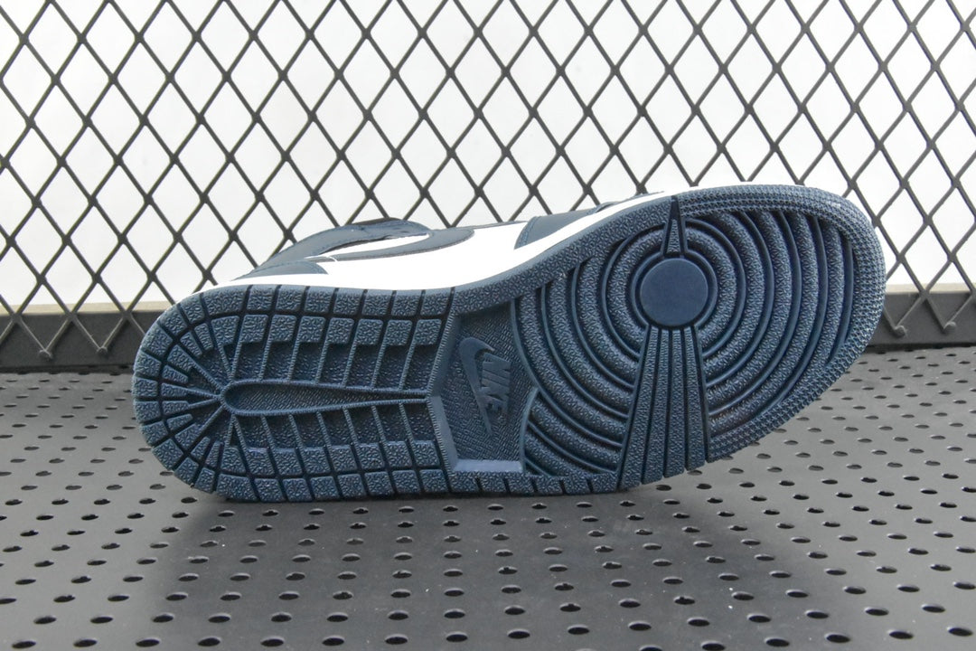 Outsole view of mid-top sneakers with dark teal traction tread and white upper
