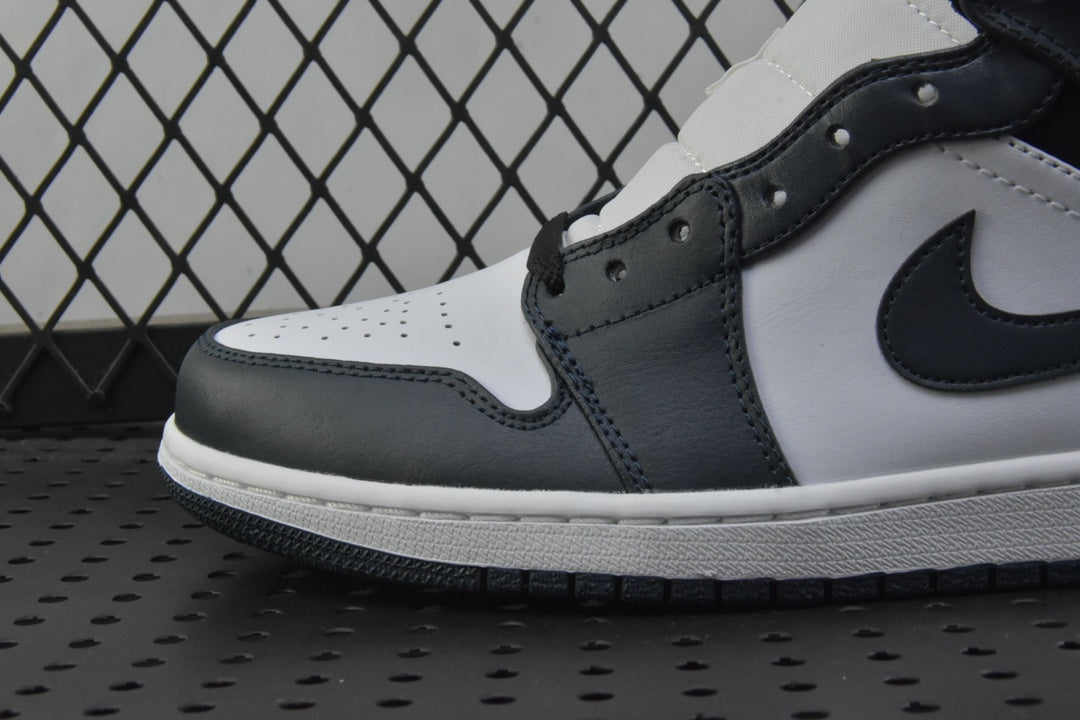Close-up side of mid-top sneakers with white leather panels and dark teal swoosh