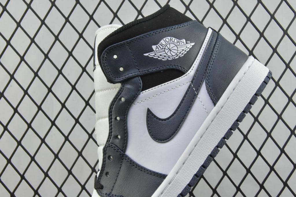 Heel and ankle area of mid-top sneakers with dark teal strap detail and white panels