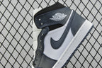 Heel and ankle area of mid-top sneakers with dark teal strap detail and white panels