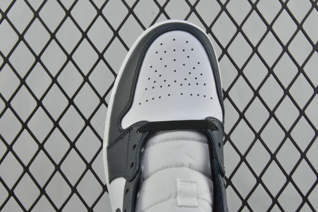 Top view of mid-top sneaker toe box with perforations and dark teal lace eyelets