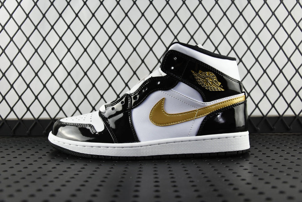 Air Jordan 1 Mid sneakers, black and white with gold swoosh, lace-up mid-top