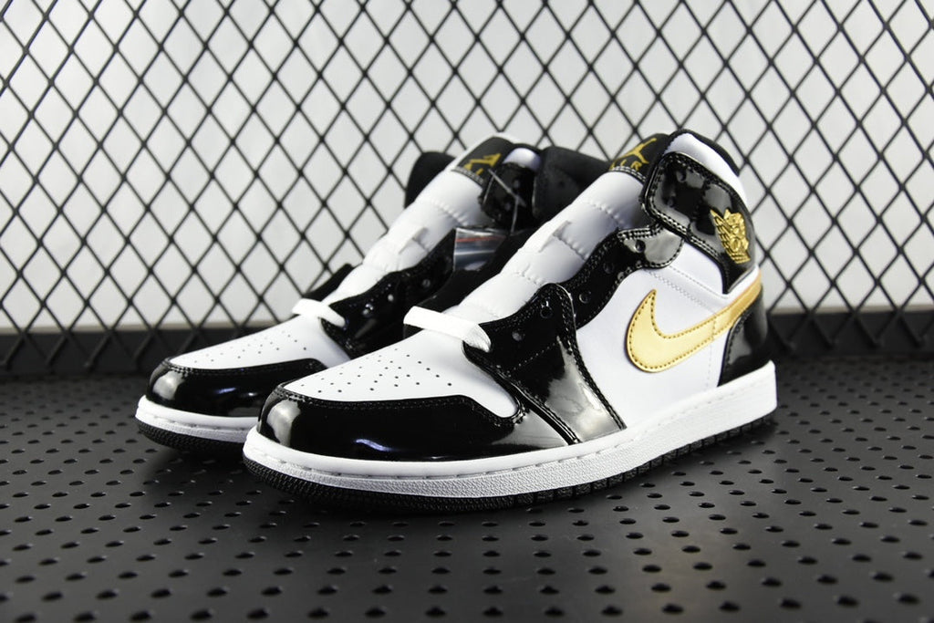 Air Jordan 1 Mid sneakers pair view, black patent and white leather with gold swoosh