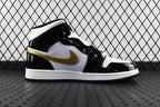 Air Jordan 1 Mid sneaker, black and white leather with gold swoosh, side profile