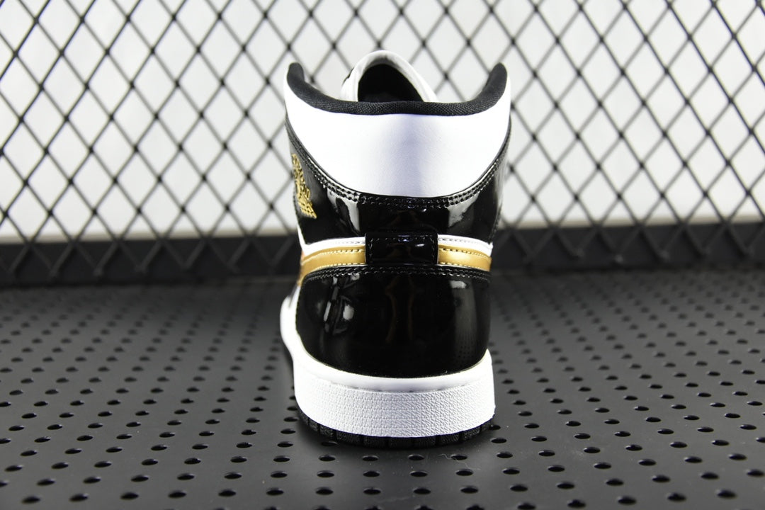 Air Jordan 1 Mid sneaker heel view, black upper with gold stripe and white sole