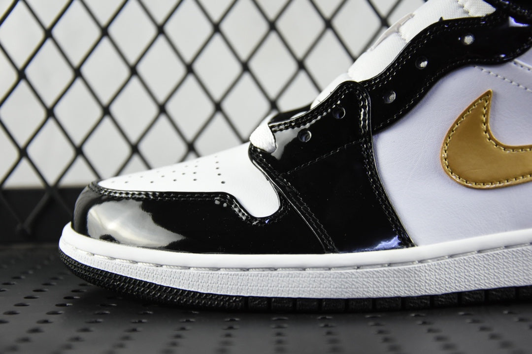 Air Jordan 1 Mid sneaker close-up, black glossy toe and white panel with gold swoosh