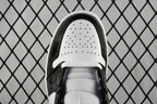 Air Jordan 1 Mid sneaker tongue view, black lining with perforated white toe box
