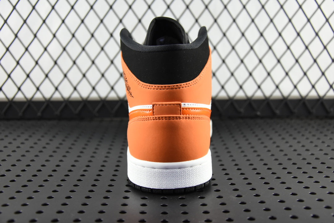 Air Jordan 1 Mid sneakers, rear view with black collar and orange heel panel